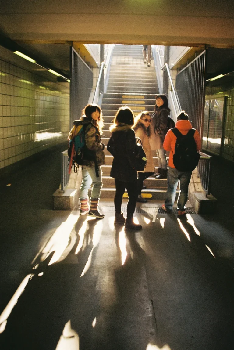 People exiting a Berlin subway station into daylight, candid street scene with soft shadows and urban architecture, 35mm film photography by Percy Lin 2016