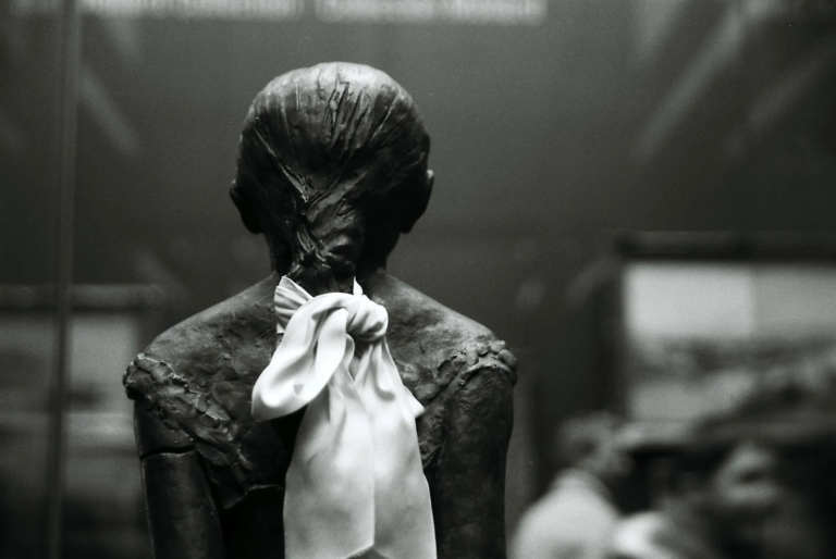 Back view of Edgar Degas ballet dancer sculpture with a white ribbon inside Musée d’Orsay, black and white 35mm film photography by Percy Lin 2016